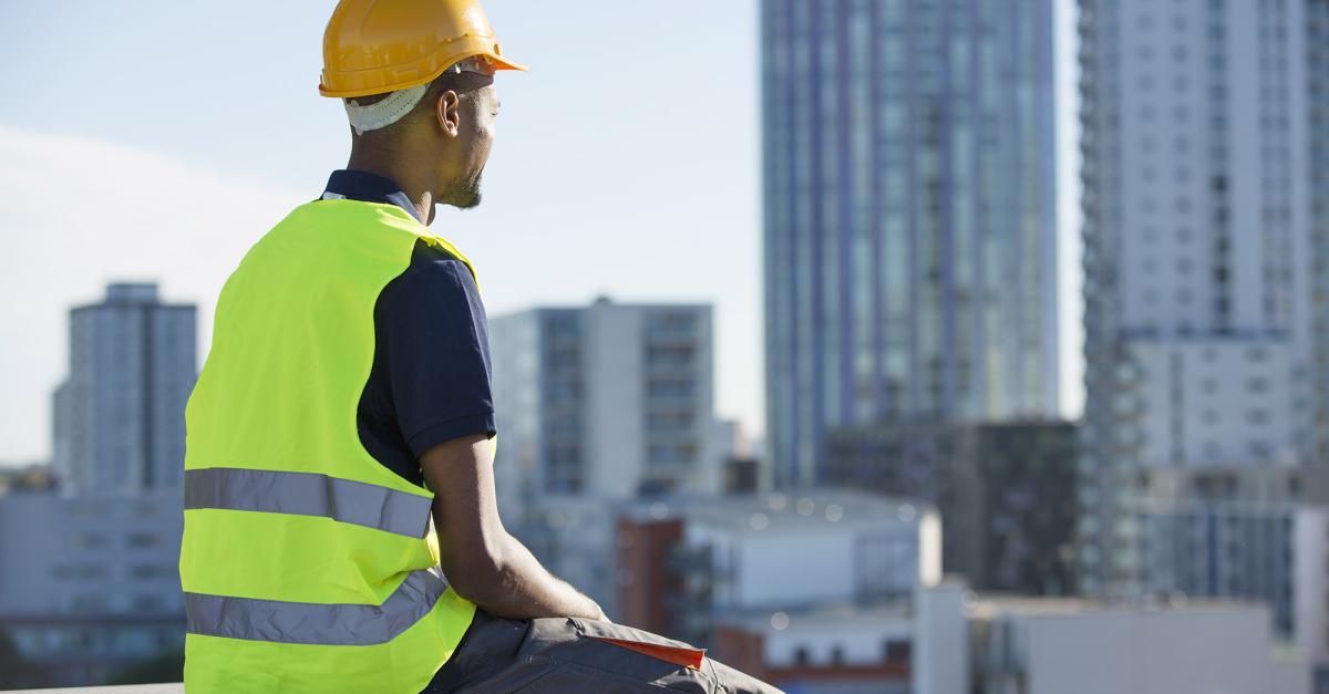 Construction worker sitting on building