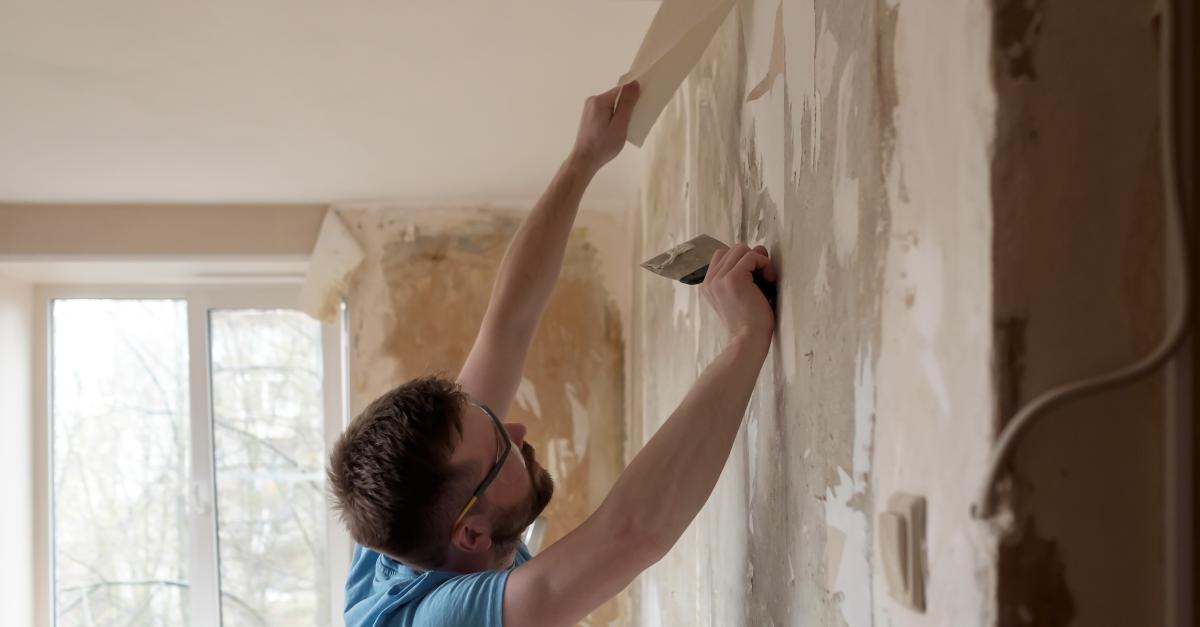 Man removing old wallpaper